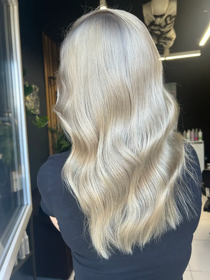 Păr blond platinat, glacial, coafat în valuri moi, realizat la BLOOM Hair Salon Târgu-Mureș